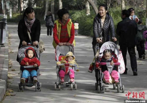 Three mothers with their children chat on a street of Zhengzhou, Henan province on Nov 11, 2013. (Photo: China News Service/Wang Zhongju)