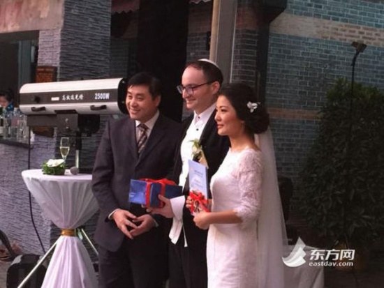 The head of the museum poses with the newly-wed couple on April 1, 2015.(Photo/eastday.com)