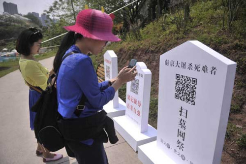 Visitors to a cemetery scan QR codes on tombstones. (China Daily/Chen Chao) 