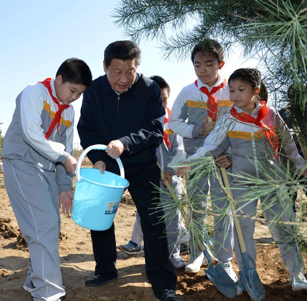President Xi Jinping plants and waters trees with primary school pupils in Beijing on Friday. The other six members of the CPC Political Bureau Standing Committee, Li Keqiang, Zhang Dejiang, Yu Zhengsheng, Liu Yunshan, Wang Qishan and Zhang Gaoli, also attended the event. (Photo by Zhang Wei / For China Daily)