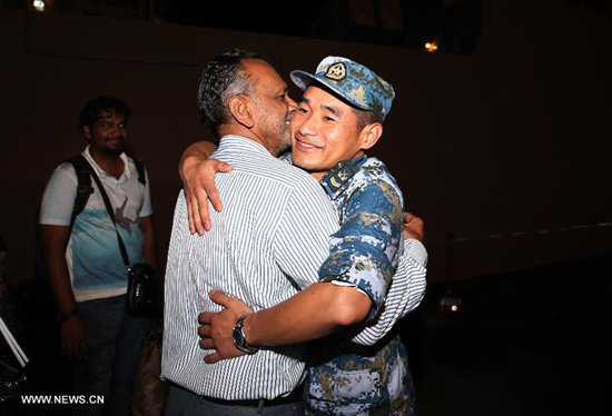 A Sri Lankan national embraces a crew member of the Chinese Linyi missile frigate in Djibouti, on April 7, 2015. A total of 38 Chinese nationals and 45 Sri Lankans evacuated by the Chinese frigate from Yemen arrived in Djibouti early Tuesday. (Xinhua/Pan Siwei)