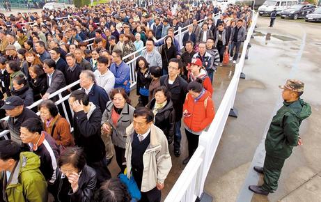 Crowds queue for shuttle buses taking them to a cemetery in Shanghais Jiading District yesterday. Roads in downtown areas and to cemeteries in suburban areas were gridlocked for much of the morning as residents made the Qingming Festival journey to pay respect to their ancestors. (Photo: Shanghai Daily/Xu Xiaolin)
