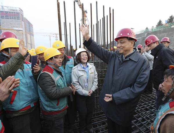 Premier Li Keqiang talks to workers on Thursday at a transportation hub being built in Changchun, Jilin province. DINGLIN/ XINHUA