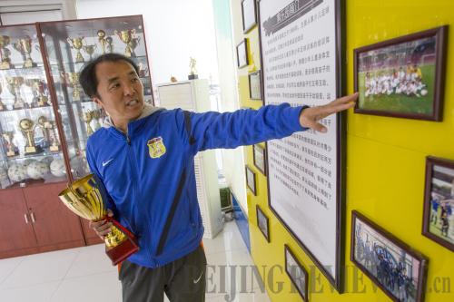 STORIED HISTORY: Gao Chao, a football coach and founder of Beijing-based Silver Tide Football Club, shows off some of the club's achievements on April 1 (WANG XIANG)