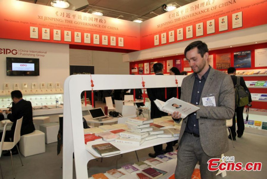 A visitor reads Xi Jinping: The Governance of China at the London Book Fair in London, April 14, 2015. The book, published by Chinas Foreign Language Press, is available in multiple languages, including Chinese, English, French, Russian, Arabic, Spanish, Portuguese, German and Japanese. (Photo: China News Service/Zhou Zhaojun)