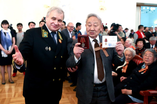 Russian Ambassador to China Andrei Denisov presents a medal on Wednesday to Han Moning, a Chinese veteran who worked in the former Soviet Union, at a ceremony in Beijing marking the 70th anniversary of victory in the Great Patriotic War (1941-45). (China Daily/Feng Yongbin)