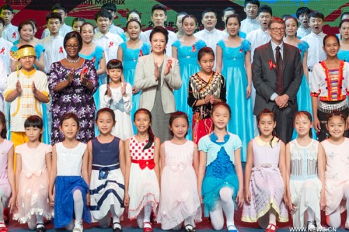 Chinese President Xi Jinping's wife Peng Liyuan (C), who is the World Health Organization (WHO)'s goodwill ambassador for tuberculosis and HIV/AIDS, attends a publicizing activity for the prevention and cure of tuberculosis and HIV/AIDS in Hainan University in Haikou, South China's Hainan province, March 29, 2015. (Photo/Xinhua)