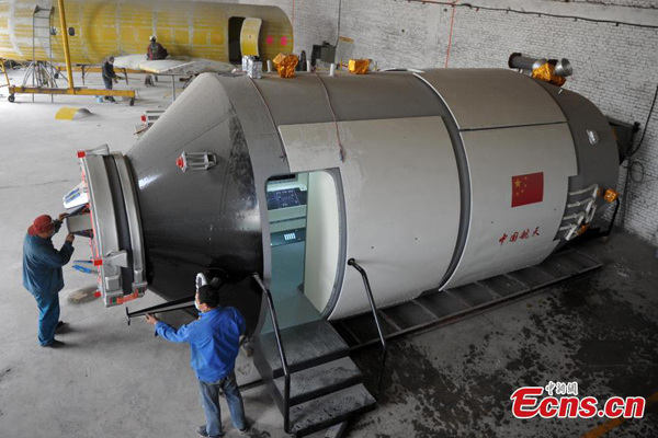 Workers construct a replica of the Chinese prototype space lab Tiangong-1 in Shijiazhuang, North Chinas Hebei province, April 15, 2015. (Photo: China News Service/Zhai Rujia)