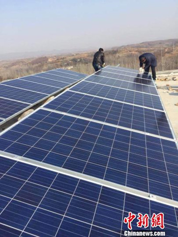 Farmers install photovoltaic modules in Henan in Jan 2015. (Photo: China News service/Meng Fei)