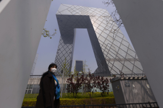 A woman wears a mask while walking on Guanghua Road in Beijing on Thursday as the city is shrouded in haze for a second day. (Photo: China Daily/Wei Xiaohao)