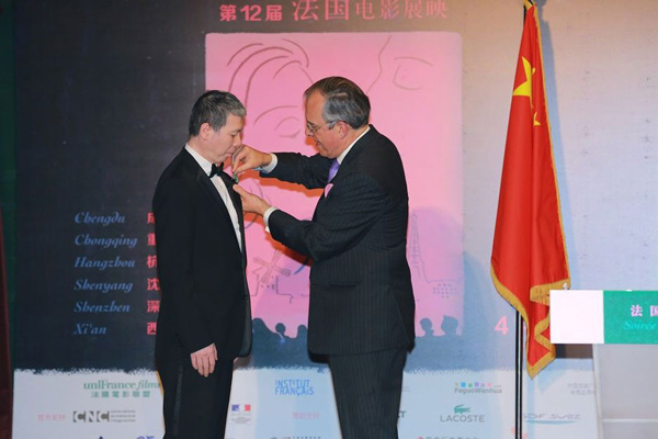 Chinese director Feng Xiaogang is awarded the Ordre des Arts et des Lettres in Beijing on April 18, 2015. (Photo/Xinhua)