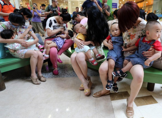 Activist mothers breast-feed their babies for five minutes in a shopping mall in Qingdao, Shandong province, on June 28 to promote the importance of breast-feeding. (Photo/China Daily)