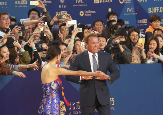 Arnold Schwarzenegger draws a big crowd of fans while walking the red carpet of the Beijing International Film Festival.(Photo By Jiang Dong/China Daily)