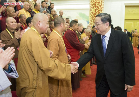 Yu Zhengsheng (R), chairman of the National Committee of the Chinese People's Political Consultative Conference, shakes hands with representatives of the Buddhist Association of China, in Beijing, China, April 21, 2015. (Xinhua/Huang Jingwen)