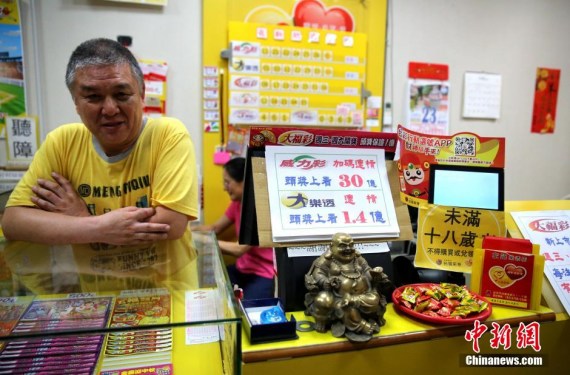 A man shows a ticket which wins the biggest ever jackpot of 3 billion new Taiwan dollars (about 100 million U.S. dollars) in Taiwan's super lottery Thursday. (Photo: Chen Xiaoyuan/China News Service) 