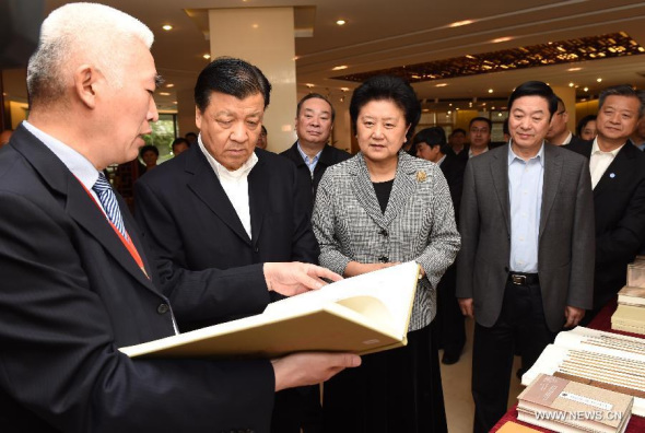 Liu Yunshan (2nd L), a member of the Standing Committee of the Communist Party of China (CPC) Central Committee, listens to introductions at an exhibition stand in the Zhonghua Book Company in Beijing, capital of China, on April 23, 2015.(Xinhua/Rao Aimin)