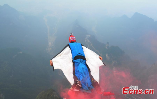 A flier leaps from the Tianmen Mountain during the final competition of the third Wingsuit World Flying Contest held in Tianmen Mountain in Zhangjiajie sightseeing spot of Central Chinas Hunan province on October 19, 2014. (Photo: China News Service/Yang Huafeng)