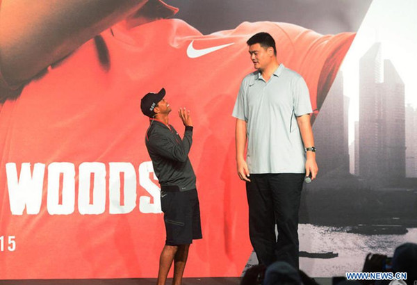 Tiger Woods talks to Yao Ming in his commercial visit to Shanghai on April 24, 2015. (Photo/Xinhua)