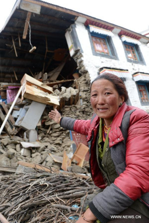 A woman weeps in front of a collapsed house in Nyalam County of Xigaze Prefecture, southwest China's Tibet Autonomous Region, April 26, 2015.(Xinhua/Chogo) 