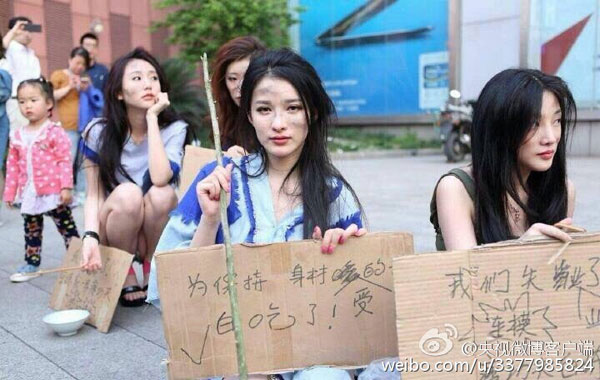 Showgirls dressed as beggars carry placards during the protest. (Photo from Sina Weibo)