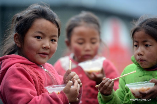Tibetan kids eat breakfast supplied by rescue teams in Jilung County of Xigaze City, southwest China's Tibet Autonomous Region, April 27, 2015. At least 20 people were confirmed dead, 58 people injured and another four missing in Tibet after the earthquake that struck neighboring Nepal on Saturday. Some 24,803 people have been relocated in Tibet's Xigaze City. (Xinhua/Chen Tianhu)