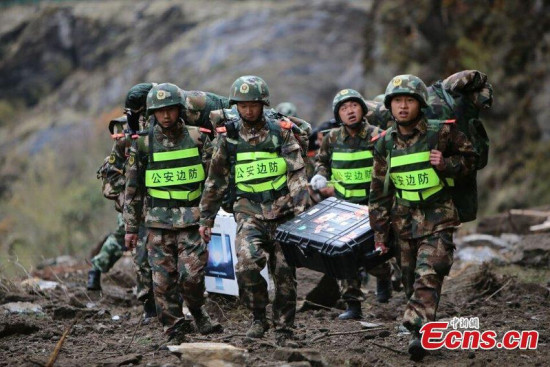 Rescuers carrying relief items walk to the quake-hit Zham town of Xigaze city, Southwest China's Tibet autonomous region. The town, one of the most seriously effected areas in Tibet, has been cut off for 70 hours due to landslides and avalanches. (Photo/CFP)