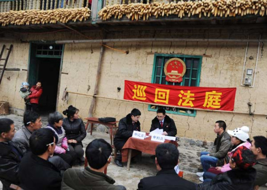 Two judges from a court in Fengjie county, Chongqing, resolve civil disputes among villagers in Taoyuan in March. Such circuit courts have been set up to improve efficiency. (China Daily/Rao Guojun)