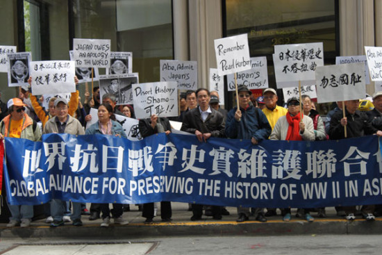 Over 500 people participate in a demonstration on Wednesday along the street where the Japanese Consulate General in San Francisco is located. They hold signs and chant slogans demanding the visiting Japanese Prime Minister Shinzo Abe make an apology. Lia Zhu/China Daily.  