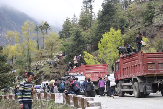 Vehicles carrying earthquake-affected people wait as landslides occur on Wednesday. (Photo by Daqiong and Palden Nyima/chinadaily.com.cn)