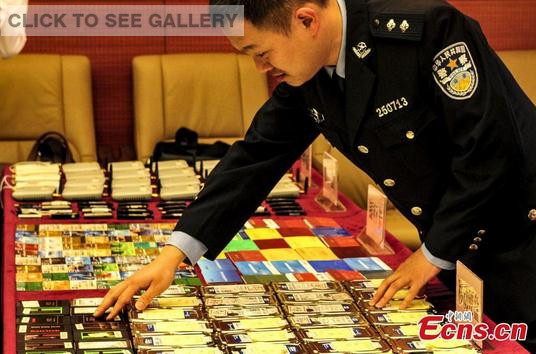  A policeman shows items confiscated from busting an online gambling ring in Guangzhou, South China's Guangdong province, April 1, 2015. (Photo: China News Service/Chen Jimin)