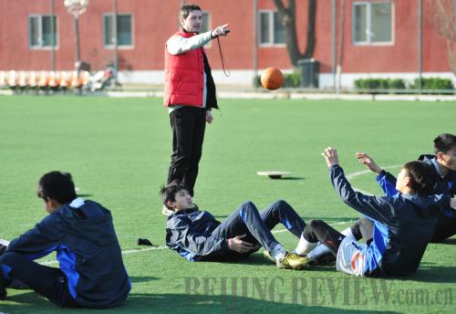 FOREIGN EXPERTISE: Marko Tomic, a 31-year-old assistant coach from Serbia, guides students in their warm up before regular training starts on a field inside the Sangao training base on April 7 (WEI YAO)