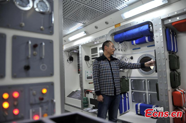 Xu Weilong shows off a replica of the Chinese prototype space lab Tiangong-1 in Shijiazhuang, North China's Hebei province, April 15, 2015. (Photo: China News Service/Zhai Rujia) 