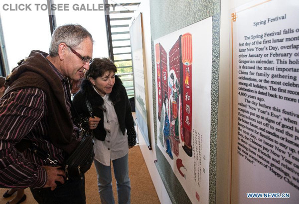 A French couple show great interests in a piece of Chinese paper-cut works during an exhibition in Geneva, Switzerland, April 20, 2015. Hundreds of guests participated in a "Chinese Etiquette" paper-cut exhibition, co-organized by the United Nations Office at Geneva and the Chinese Permanent Mission to UN at Geneva, as part of the celebrations for the UN Chinese Language Day. (Photo: Xinhua/Xu Jinquan)