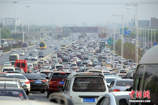 Stuck in gridlock, queues of cars wait at the entrance of a highway in Zhengzhou of Henan Province on May 1, the first day of China's May Day holiday. Many drivers are trying to take advantage of a policy that waives the toll on expressways during holidays. (PhotoChina News Service/Feng Lei)