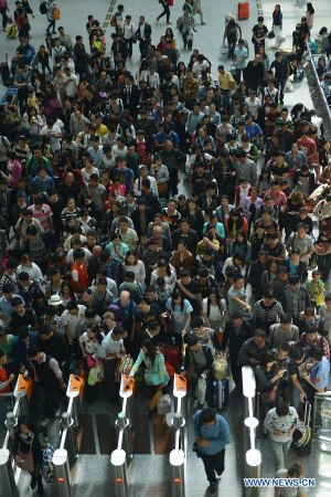Passengers pass through the ticket barrier at a railway station in Hangzhou, capital of east China's Zhejiang Province, May 3, 2015. The railway and bus stations across the nation witnessed surging passenger flows on Sunday as the three-day Labor Day Holiday came to end and people started to return to work. (Xinhua/Long Wei)