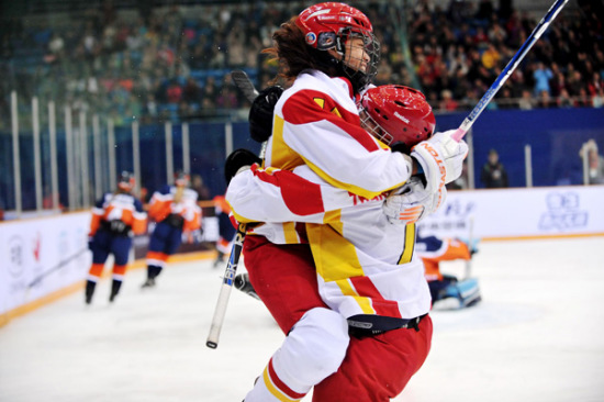 Captain Sun Rui is embraced by one of her teammates after scoring during a game at the IIHF Women's World Championship Division I Group B in Beijing on April 6. The Chinese team lost to the Netherlands 3-2 after penalties. (Photo/China Daily)