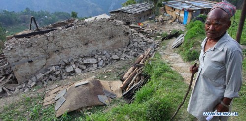 An elderly man asks for relief in front of his damaged house in Sindhupalchowk, Nepal, on May 5, 2015. (Xinhua/Sunil Sharma)