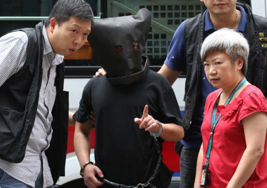 Police officers bring a suspect on Tuesday to the scene of a kidnapping last week in Ngau Chi Wan, Hong Kong. (Photo/China Daily)
