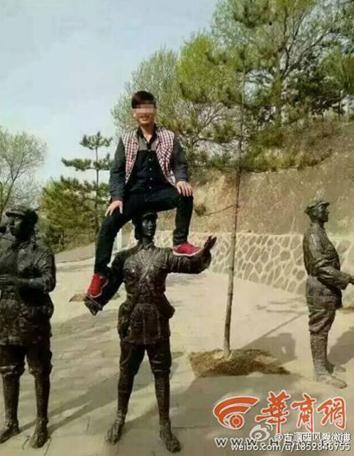 Tourist Li Wenchun climbs on top of a Red Army statue for a photo on April 23, 2015. （Photo/Weibo）