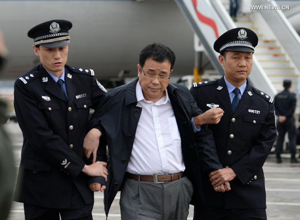 Chinese police escort Li Huabo (C), the second suspect from China's 100 most wanted economic fugitives list, upon his arrival at the Beijing Capital International Airport in Beijing, capital of China, May 9, 2015. Li was repatriated Saturday as part of operation Sky Net. The Sky Net campaign aims to return fugitives for trial. (Xinhua/Chen Yehua)