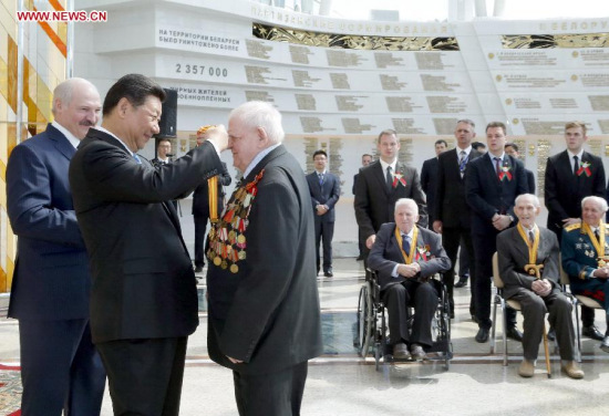 Chinese President Xi Jinping (2nd L) confers a medal on a Belarusian World War Two (WWII) veteran at the Belarusian State Museum of the Great Patriotic War during a meeting with 15 Belarusian World War Two (WWII) veterans in the company of Belarusian President Alexander Lukashenko (1st L) in Minsk, capital of Belarus, May 11, 2015. Xi arrived here Sunday for a three-day state visit to Belarus, the first by a Chinese head of state in 14 years. (Xinhua/Ju Peng)