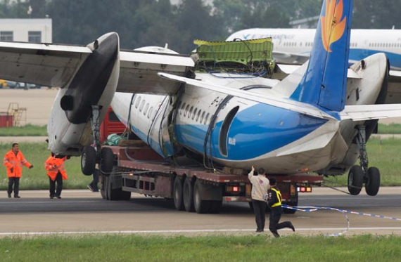 A damaged MA-60 aircraft is transported after it skidded off a runway at an airport in Fuzhou, Fujian province, on Sunday. Seven passengers were slightly injured in the incident. (Xinhua/Jiang Kehong)