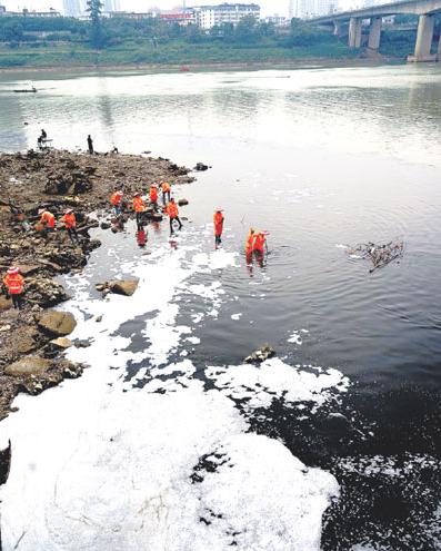 Workers clean an area near a sewage outlet in Nanning in the Guangxi Zhuang autonomous region. (Tang Huiji/for China Daily)