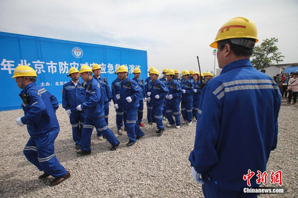 Rescuers line up during a disaster prevention and mitigation drill in Beijing, capital of China on May 11, 2015, to mark the May 12 National Disaster Prevention and Mitigation Day. (Photo/Chinanews.com)