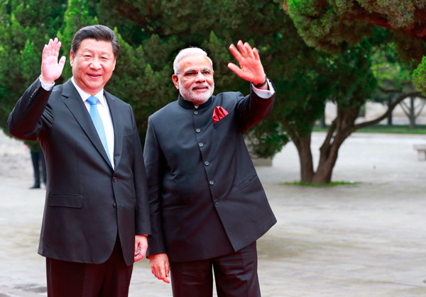 President Xi Jinping and Indian Prime Minister Narendra Modi greet well-wishers at the Daci'en Temple in Xi'an, Shaanxi province, on Thursday. (Photo: China Daily/Feng Yongbin)