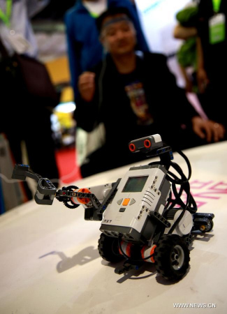A visitor controls a robot by his mind during the 18th China Beijing International High-Tech Expo in Beijing, capital of China, May 13, 2015. About 1,600 exhibitors of high-tech industry show on the expo which opened on Wednesday. (Xinhua/Pan Xu)