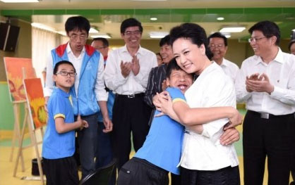 Peng Liyuan, President Xi Jinping's wife, calls on the Beijing Disabled Persons Rehabilitation Service and Guidance Center to visit the children with autism, and talk to teachers and parents in Beijing on May 18, 2015. (Photo/Beijing Times)
