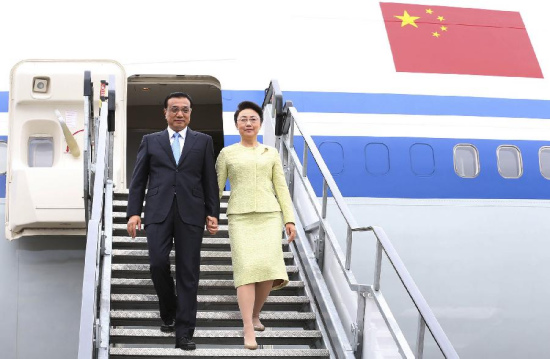 Chinese Premier Li Keqiang (L) and his wife, Prof. Cheng Hong disembark when arriving at the airport of Shannon, Ireland, May 17, 2015. Irish Finance Minister Michael Noonan, Chinese Ambassador Xu Jianguo came to welcome Li and his wife at the airport. Li arrived here Sunday for a transit visit to Ireland before heading to Latin America for an official visit to Brazil. (Xinhua/Huang Jingwen)