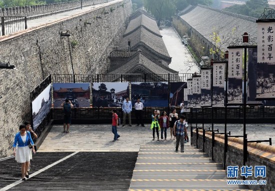 Visitors look at old photos on an exhibit held by the Palace Museum on May 17, 2015. (Photo: Xinhua/Jin Liangkuai)