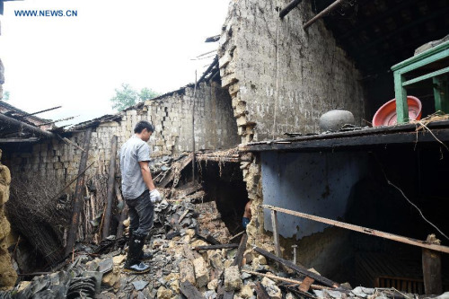 A villager clears the rubble of a house that is destroyed by heavy rain at Luojin Township of Yongfu County, south China's Guangxi Zhuang Autonomous Region, May 17, 2015. (Xinhua/Lu Boan)